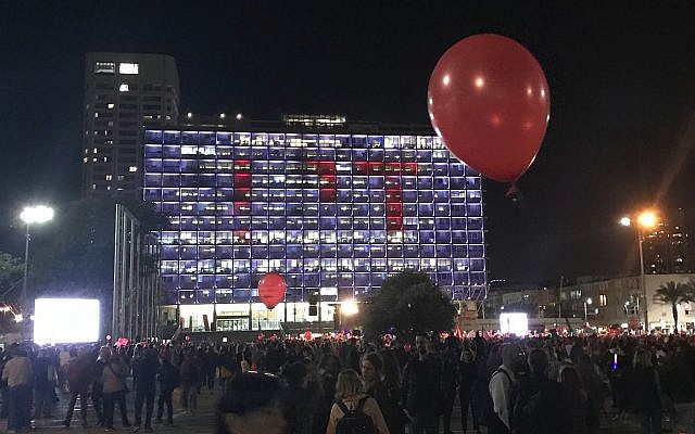 La mairie de Tel Aviv éclairée par la projection du mot "Assez" en hébreu alors que des milliers de  manifestantes sont réunies sur la place Rabin de Tel Aviv dans le cadre d'une grève nationale de protestation contre les violences faites aux femmes, le 4 décembre 2018 (Crédit : Luke Tress/Times o fIsrael)