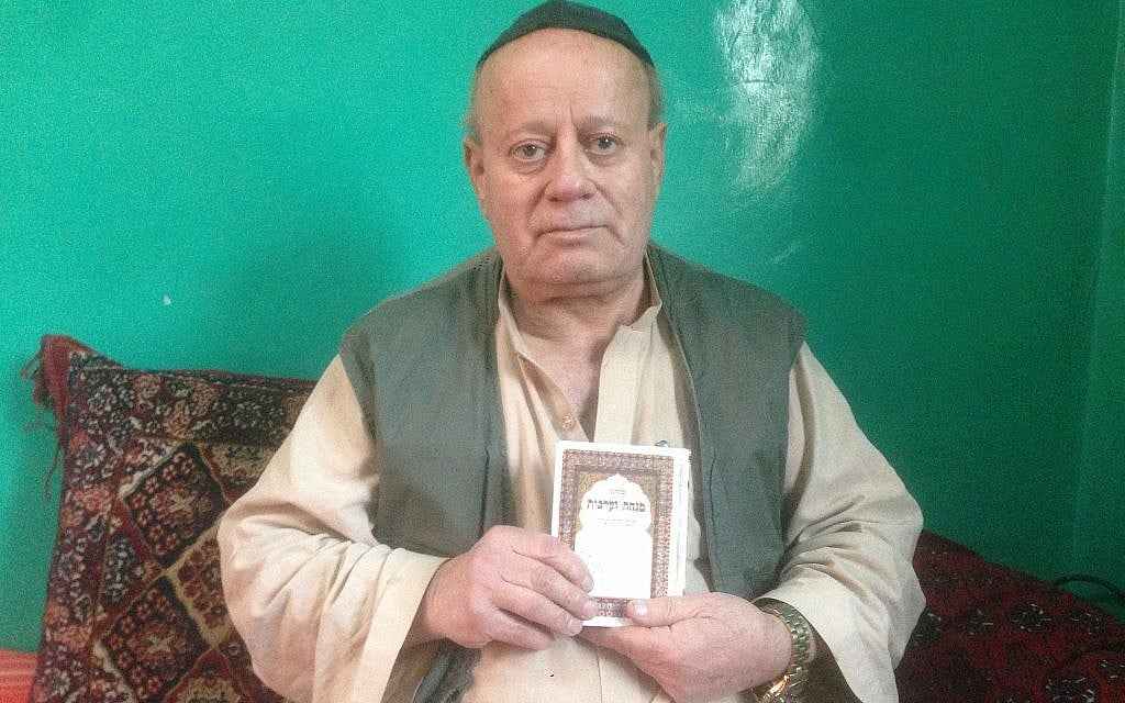 Zabolon Simantov avec son livre de prières juives (Crédit : Ezzatullah Mehrdad/ Times of Israel)