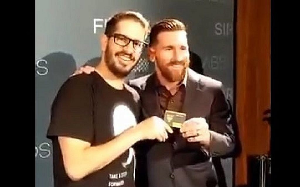 Lionel Messi (à droite), star du football argentin, reçoit sa carte de membre du fan club du Beitar Jerusalem des mains du propriétaire du club, Moshe Hogeg, lors d'un événement à Barcelone, Espagne, en décembre 2018. (Capture d'écran : Twitter) Lionel Messi (à droite), star du football argentin, reçoit sa carte de membre du fan club du Beitar Jerusalem des mains du propriétaire du club, Moshe Hogeg, lors d'un événement à Barcelone, Espagne, en décembre 2018. (Capture d'écran : Twitter)