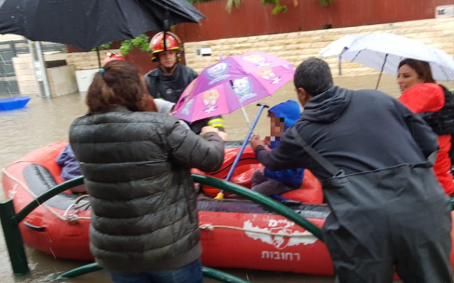 Des enfants asauvés d'une inondation par  bateau,  à cause d'importantes précipitions le 6 décembres 2018. (Crédit ; capture d'écran Hadashot)