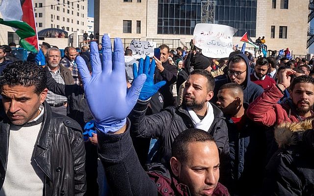 Des Palestiniens protestent contre une hausse des impôts à Ramallah, en Cisjordanie, le 12 décembre 2018. Les gants bleus sont un symbole d'union pour les manifestants, comme les Gilets jaunes portés lors des récents mouvements de protestation en France (Crédit : Luke Tress/Times of Israel) Des Palestiniens protestent contre une hausse des impôts à Ramallah, en Cisjordanie, le 12 décembre 2018. Les gants bleus sont un symbole d'union pour les manifestants, comme les Gilets jaunes portés lors des récents mouvements de protestation en France (Crédit : Luke Tress/Times of Israel)