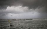Un véliplanchiste surfe sur les vagues de la mer Méditerranée à Tel Aviv le 16 janvier 2019. (AP Photo/Oded Balilty)