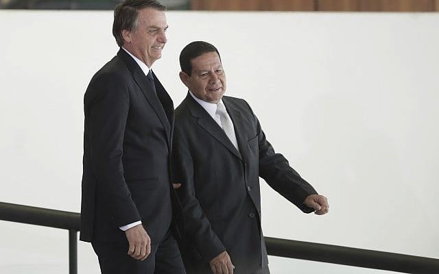 Le président brésilien Jair Bolsonaro, à gauche, se rend avec son vice-président Hamilton Mourao à une cérémonie au cours de laquelle les présidents des banques d'État du pays seront présentés au palais présidentiel Planalto de Brasilia, au Brésil, le lundi 7 janvier 2019. (Crédit : AP / Eraldo Peres) Le président brésilien Jair Bolsonaro, à gauche, se rend avec son vice-président Hamilton Mourao à une cérémonie au cours de laquelle les présidents des banques d'État du pays seront présentés au palais présidentiel Planalto de Brasilia, au Brésil, le lundi 7 janvier 2019. (Crédit : AP / Eraldo Peres)