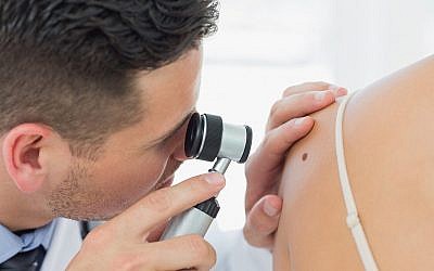Illustration : Un dermatologue examine un grain de beauté. (Wavebreakmedia ; iStock by Getty Images)