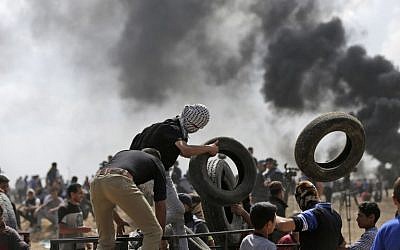 Des manifestants palestiniens brûlent des pneus près de la frontière entre Gaza et Israël, à l'est de la ville de Gaza, lors de manifestations contre l'inauguration de l'ambassade des États-Unis à Jérusalem, le 14 mai 2018. (AFP Photo/Mahmud Hams)