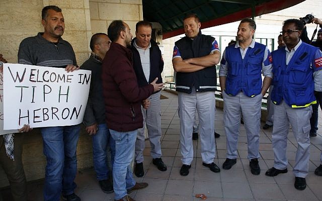 Des observateurs de la Présence internationale temporaire à Hébron (TIPH) aux côtés de Palestiniens qui dénoncent la décision de Benjamin Netanyahu de ne pas reconduire le mandat de la TIPH, à Hébron, le 30 janvier 20019. (Crédit : HAZEM BADER / AFP) Des observateurs de la Présence internationale temporaire à Hébron (TIPH) aux côtés de Palestiniens qui dénoncent la décision de Benjamin Netanyahu de ne pas reconduire le mandat de la TIPH, à Hébron, le 30 janvier 20019. (Crédit : HAZEM BADER / AFP)