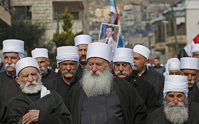 Des résidents druzes du plateau du Golan portent un portrait du président syrien Bashar al-Assad pendant un rassemblement dans le village de Majdal Shams, le 14 février 2019 (Crédit :  JALAA MAREY / AFP)
