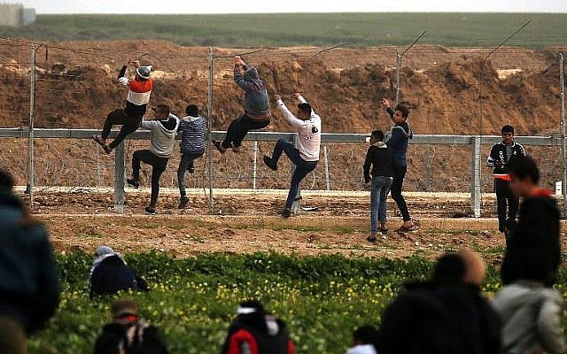 Des Palestiniens escaladent la clôture de sécurité le long de la frontière entre Israël et la bande de Gaza, lors d'affrontements à l'est de la ville de Gaza, le 15 février 2019. (Saïd Khatib/AFP) Des Palestiniens escaladent la clôture de sécurité le long de la frontière entre Israël et la bande de Gaza, lors d'affrontements à l'est de la ville de Gaza, le 15 février 2019. (Saïd Khatib/AFP)