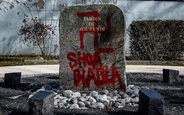 Une croix gammée et les mots 'Shoa blabla' inscrits sur le monument aux morts situé dans le jardin du Souvenir au cimetière de Champagne-au-Mont-d'Or, le 20 février 2019. (Crédit : JEFF PACHOUD / AFP) Une croix gammée et les mots 'Shoa blabla' inscrits sur le monument aux morts situé dans le jardin du Souvenir au cimetière de Champagne-au-Mont-d'Or, le 20 février 2019. (Crédit : JEFF PACHOUD / AFP)