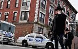 Des juifs orthodoxes dans le quartier de Crown Heights, à Brooklyn, le 27 février 2019. En arrière plan, un véhicule de la Crown Heights Shmira Patrol, une patroulle de sécurité mise en place par la communauté juive, dans un contexte d'antisémitisme ambiant. (Crédit : Angela Weiss / AFP)