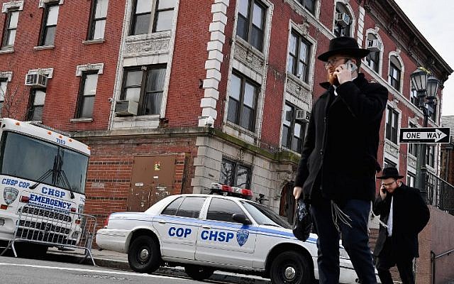Des juifs orthodoxes dans le quartier de Crown Heights, à Brooklyn, le 27 février 2019. En arrière plan, un véhicule de la Crown Heights Shmira Patrol, une patroulle de sécurité mise en place par la communauté juive, dans un contexte d'antisémitisme ambiant. (Crédit : Angela Weiss / AFP) Des juifs orthodoxes dans le quartier de Crown Heights, à Brooklyn, le 27 février 2019. En arrière plan, un véhicule de la Crown Heights Shmira Patrol, une patroulle de sécurité mise en place par la communauté juive, dans un contexte d'antisémitisme ambiant. (Crédit : Angela Weiss / AFP)
