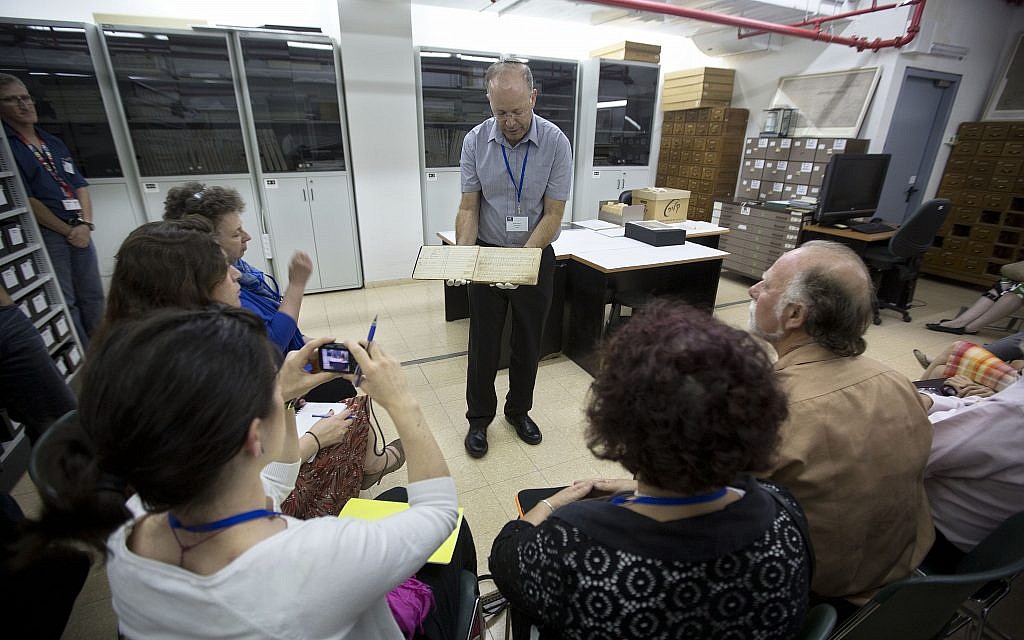 Le directeur des archives de Yad Vashem, Haim Gertner, montre un document à des experts internationaux en visite et à d'autres personnes qui participent à un atelier consacré à la préservation physique et numérique des documents, à Jérusalem, en septembre 2014. (AP Photo/Sebastian Scheiner)