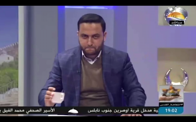 Un présentateur de la chaîne Al-Aqsa TV pose une tasse sur son bureau, un geste que le Shin Bet a déclaré être un code secret adressé à des terroristes en Cisjordanie (Capture d'écran: Al-Aqsa TV/ Shin Bet) Un présentateur de la chaîne Al-Aqsa TV pose une tasse sur son bureau, un geste que le Shin Bet a déclaré être un code secret adressé à des terroristes en Cisjordanie (Capture d'écran: Al-Aqsa TV/ Shin Bet)