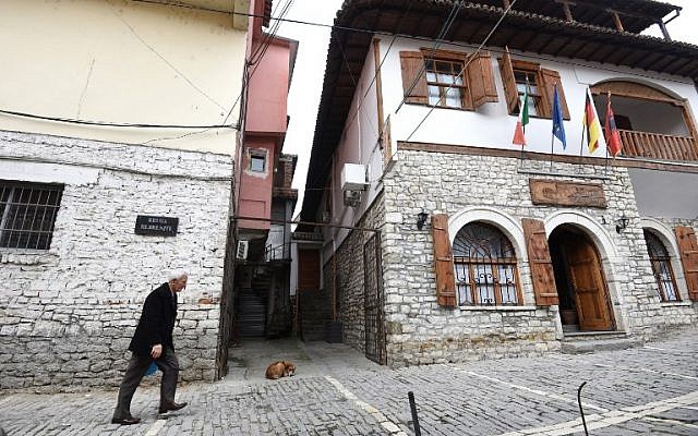 Un homme marche dans une rue de la ville de Berat, en Albanie, le 6 février 2019. (Crédit : Gent SHKULLAKU / AFP)