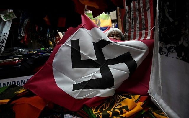 Un drapeau nazi en vente sur l'étal d'un marché de Bangkok, en Thaïlande., (Crédit : Lillian SUWANRUMPHA / AFP) Un drapeau nazi en vente sur l'étal d'un marché de Bangkok, en Thaïlande., (Crédit : Lillian SUWANRUMPHA / AFP)