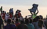 Un homme porte un débris d'avion sur le lieu du crash du Boeing d'Ethiopian Airlines, le 12 mars 2019. (Crédit : Michael TEWELDE / AFP))