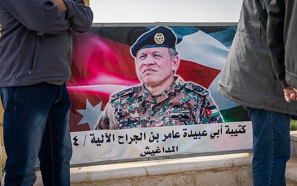 Des touristes israéliens se tiennent devant une affiche du roi Abdallah II de Jordanie sur l'île de la Paix, le 29 janvier 2019. (Luke Tress/Times of Israel)