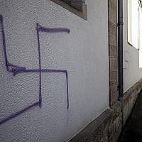 Illustration : Une croix gammée sur le mur d'une ancienne synagogue à Mommenheim, dans l'est de la France, le 4 mars 2019. (Crédit : Jean-François Badias/AP)