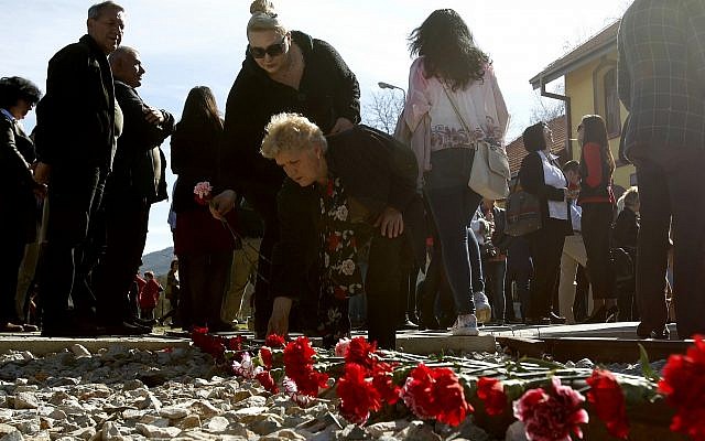 Des fleurs sont posées sur les rails au cours d'une cérémonie de commémoration des victimes de la Shoah à la gare de Bitola, dans le sud de la Macédoine, le 11 mars 2019 (Crédit : AP Photo/Boris Grdanoski) Des fleurs sont posées sur les rails au cours d'une cérémonie de commémoration des victimes de la Shoah à la gare de Bitola, dans le sud de la Macédoine, le 11 mars 2019 (Crédit : AP Photo/Boris Grdanoski)
