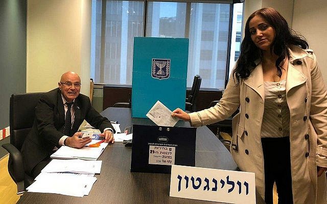 Anat Amichai, l'épouse du chef de la sécurité de l'ambassade israélienne de Wellington, Nouvelle-Zélande, dépose le premier bulletin de vote des élections pour la 21e Knesset, dans le cadre du vote anticipé permis aux diplomates et à leur famille, le 28 mars 2019. (Crédit : ministère israélien des Affaires étrangères) Anat Amichai, l'épouse du chef de la sécurité de l'ambassade israélienne de Wellington, Nouvelle-Zélande, dépose le premier bulletin de vote des élections pour la 21e Knesset, dans le cadre du vote anticipé permis aux diplomates et à leur famille, le 28 mars 2019. (Crédit : ministère israélien des Affaires étrangères)