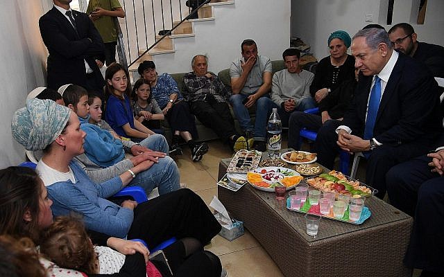 Le Premier ministre Benjamin Netanyahu, à droite, rencontre la famille du rabbin Achiad Ettinger, mort dans une attaque, dans l'implantation d'Eli, en Cisjordanie, le 19 mars 2019 (Crédit : Haim Zach/GPO)