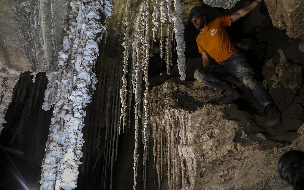Efi Cohen, membre de l'équipe de recherche de l'Université hébraïque de Jérusalem, au dessus d'un rocher dans l'une des chambres de la grotte de sel de Malham, le 27 mars 2019. (Crédit : Johanna Chisholm/Times of Israel)