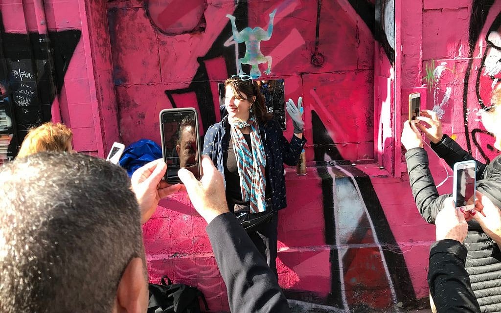 Shiry Avny devant une fresque qu'elle a taguée lors de sa démonstration d'art de rue vers la fin de sa visite guidée. (Robert Sarner/ Times of Israel)