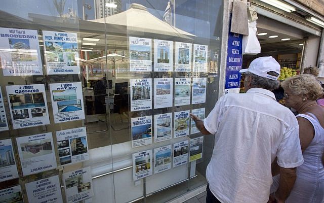 Un couple regarde des annonces immobilières dans la ville côtière de Netanya, le 29 juillet 2015. (Crédit : Sebastian Scheiner/AP) Un couple regarde des annonces immobilières dans la ville côtière de Netanya, le 29 juillet 2015. (Crédit : Sebastian Scheiner/AP)