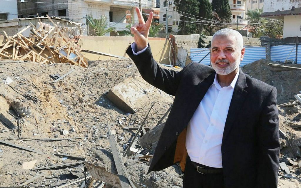 Le chef du bureau politique du Hamas Ismail Haniyeh fait le V de la victoire sur les décombres de son bureau, détruit par une frappe de l'armée israélienne, le 27 mars 2019. (Crédit : Hamas)