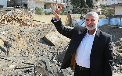 Le chef du bureau politique du Hamas Ismail Haniyeh fait le V de la victoire sur les décombres de son bureau, détruit par une frappe de l'armée israélienne, le 27 mars 2019. (Crédit : Hamas)