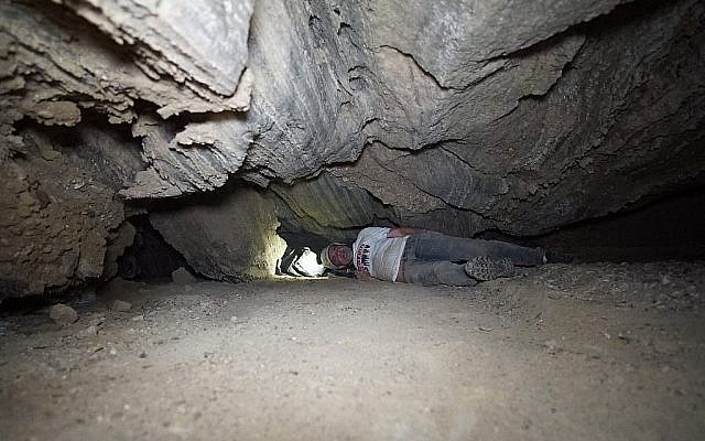 Des chercheurs se faufilent dans une brèche la grotte de Malham le 22 mars 2019. (Crédit : Anton Chikishev/Hebrew University)