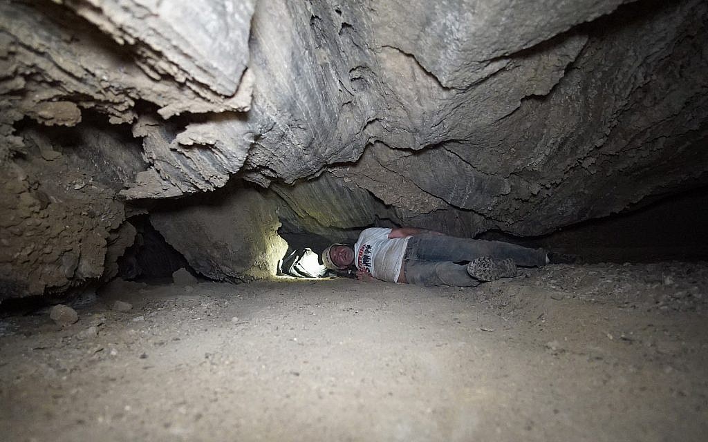 Des chercheurs se faufilent dans une brèche la grotte de Malham le 22 mars 2019. (Crédit : Anton Chikishev/Hebrew University)