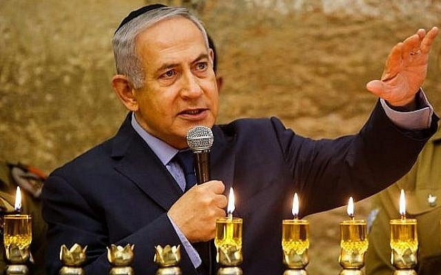 Le Premier ministre Benjamin Netanyahu, à gauche, s'exprime pendant une cérémonie d'allumage de bougies à l'occasion de la fête de Hanoukkah, au mur Occidental, dans la Vieille ville de Jérusalem, le 6 décembre 2018 (Crédit : Gil Cohen-Magen/Pool/AFP) Le Premier ministre Benjamin Netanyahu, à gauche, s'exprime pendant une cérémonie d'allumage de bougies à l'occasion de la fête de Hanoukkah, au mur Occidental, dans la Vieille ville de Jérusalem, le 6 décembre 2018 (Crédit : Gil Cohen-Magen/Pool/AFP)