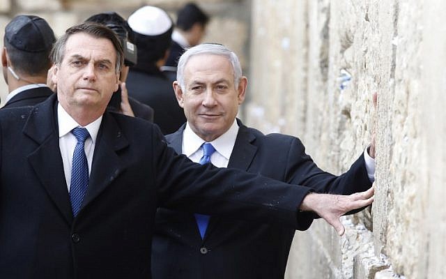 Le président brésilien Jair Bolsonaro (à gauche) et le Premier ministre Benjamin Netanyahu touchent le mur Occidental, le lieu le plus saint où les Juifs peuvent prier, dans la Vieille Ville de Jérusalem, le 1er avril 2019. (Crédit : Menahem KAHANA / POOL / AFP)