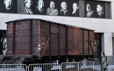 Des portraits des survivants de la Shaoh sur un wagon de train de déportation au Museum of Jewish Heritage à New York, le 2 avril 2019. (Crédit : TIMOTHY A. CLARY / AFP)