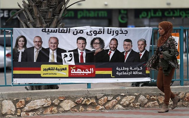 Une Arabe israélienne devant une affiche de campagne, à Kfar Menda, près de Nazareth, le 4 avril 2019. (Crédit : AHMAD GHARABLI / AFP) Une Arabe israélienne devant une affiche de campagne, à Kfar Menda, près de Nazareth, le 4 avril 2019. (Crédit : AHMAD GHARABLI / AFP)