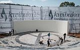 Des ouvriers nettoient les lieux au mémorial du génocide de Kigali avant le 25e anniversaire du génocide des Tutsis, au Rwanda, le 6 avril 2019 (Crédit :  Yasuyoshi CHIBA / AFP)