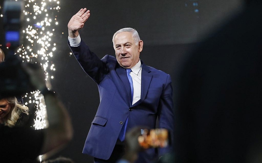 Le Premier ministre Benjamin Netanyahu salue les partisans au siège du parti du Likud, dans la ville côtière de Tel Aviv, lors de la soirée électorale dans la nuit du 10 avril 2019 (Crédit : Thomas Coex / AFP).