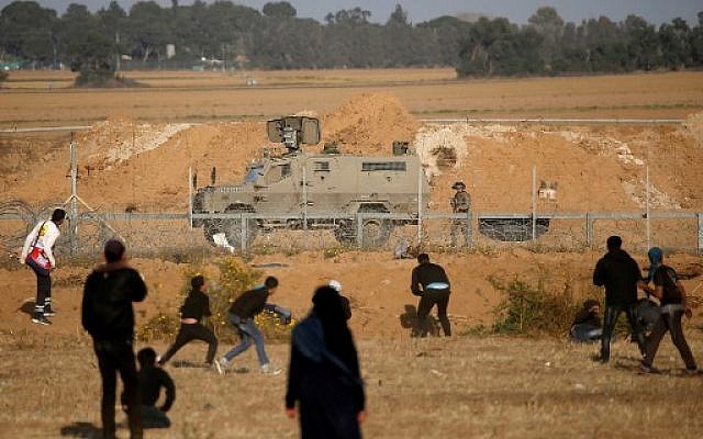 Les Palestiniens se couvrent pendant une manifestation à la frontière avec Israël, à l'est de Khan Younès, dans le sud de la bande de Gaza, le 12 avril 2019 (Crédit :  Said KHATIB / AFP)