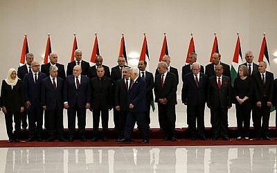 Le président de l'Autorité palestinienne Mahmoud Abbas, 6ème à droite, s'éloigne après avoir posé pour une photo de groupe avec les membres du nouveau gouvernement de l'Autorité palestinienne à Ramallah, en Cisjordanie, le 13 avril 2019 (Crédit : Abbas Momani/AFP)