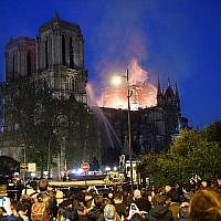 La foule assiste à l'incendie qui ravage Notre Dame de Paris, le 15 avril 2019. (Crédit : ERIC FEFERBERG / AFP)