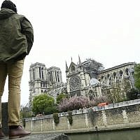 Un homme regarde l'état de la cathédrale Notre-Dame de Paris au lendemain d'un incendie, le 16 avril 2019. (Crédit : Bertrand GUAY / AFP)