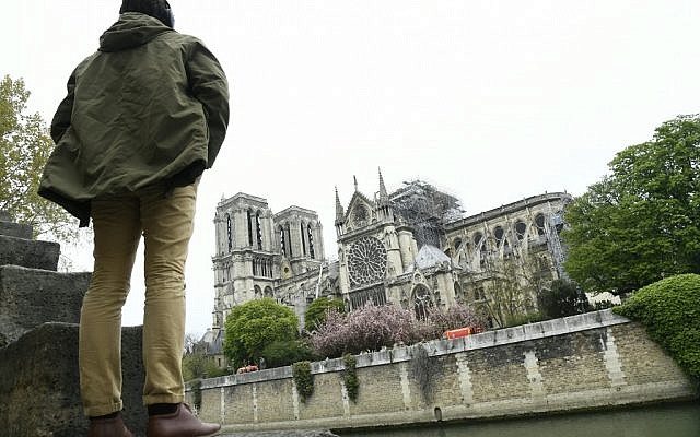 Un homme regarde l'état de la cathédrale Notre-Dame de Paris au lendemain d'un incendie, le 16 avril 2019. (Crédit : Bertrand GUAY / AFP)