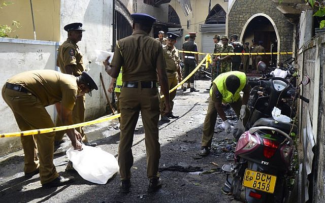 Des membres du personnel de sécurité et des enquêteurs sri-lankais examinent les débris devant l'église de Zion suite à l'explosion survenue à Batticaloa, dans l'est du Sri Lanka, le 21 avril 2019. (Crédit photo : LAKRUWAN WANNIARACHCHI / AFP)