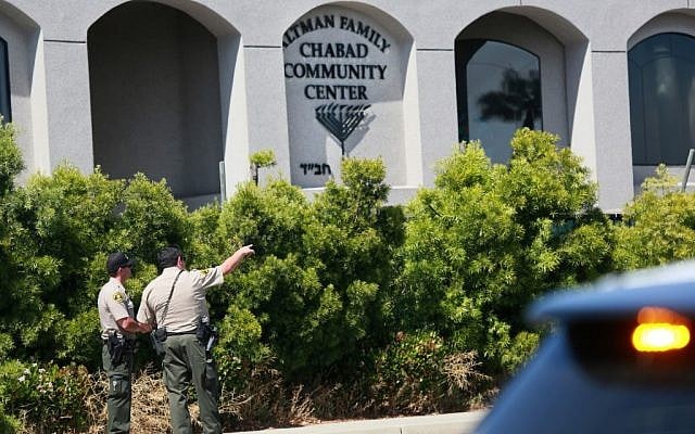 Des adjoints du shérif de San Diego regardent la synagogue de Poway, en Californie, après une fusillade, le 27 avril 2019 (Crédit : SANDY HUFFAKER / AFP)