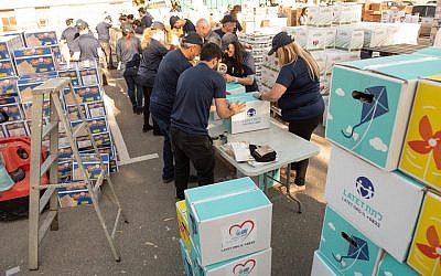 Dés bénévoles de Latet empaquetant des boites pour Pessah. (Crédit photo : Facebook/Latet)
