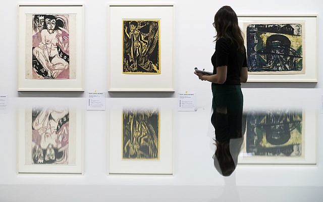 Une visiteuse observe les œuvres du peintre allemand Ernst Ludwig Kirchner présentées dans l'exposition "Collection Gurlitt, état des lieux, 'l'art dégénéré' – confisqué et vendu" du Kunstmuseum de Berne, en Suisse, novembre 2017. (Crédit : Peter Klaunzer/Keystone via AP)