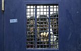 Illustration : Des prisonniers palestiniens debout dans une cellule, dans l’attente de leur libération de la prison de Ketziot, dans le sud d’Israël, le 1ᵉʳ octobre 2007. (Crédit : Ariel Schalit/AP)