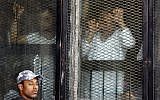 Illustration : Des accusés égyptiens attendant leur condamnation depuis une cellule en verre insonorisée, dans le tribunal improvisé de la prison de Tora, au Caire, le 28 juillet 2018. (Crédit : Amr Nabil/AP)