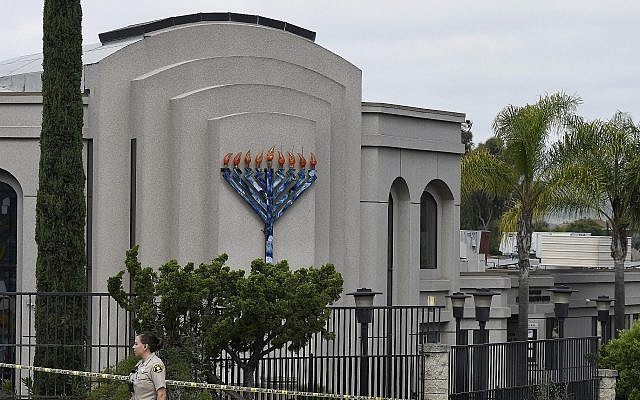 Une adjointe au shérif de San Diego devant la synagogue 'Habad de Poway, en Californie, au lendemain d'une fusillade dans le lieu de culte, le 28 avril 2019. (Crédit : AP Photo/Denis Poroy) Une adjointe au shérif de San Diego devant la synagogue 'Habad de Poway, en Californie, au lendemain d'une fusillade dans le lieu de culte, le 28 avril 2019. (Crédit : AP Photo/Denis Poroy)